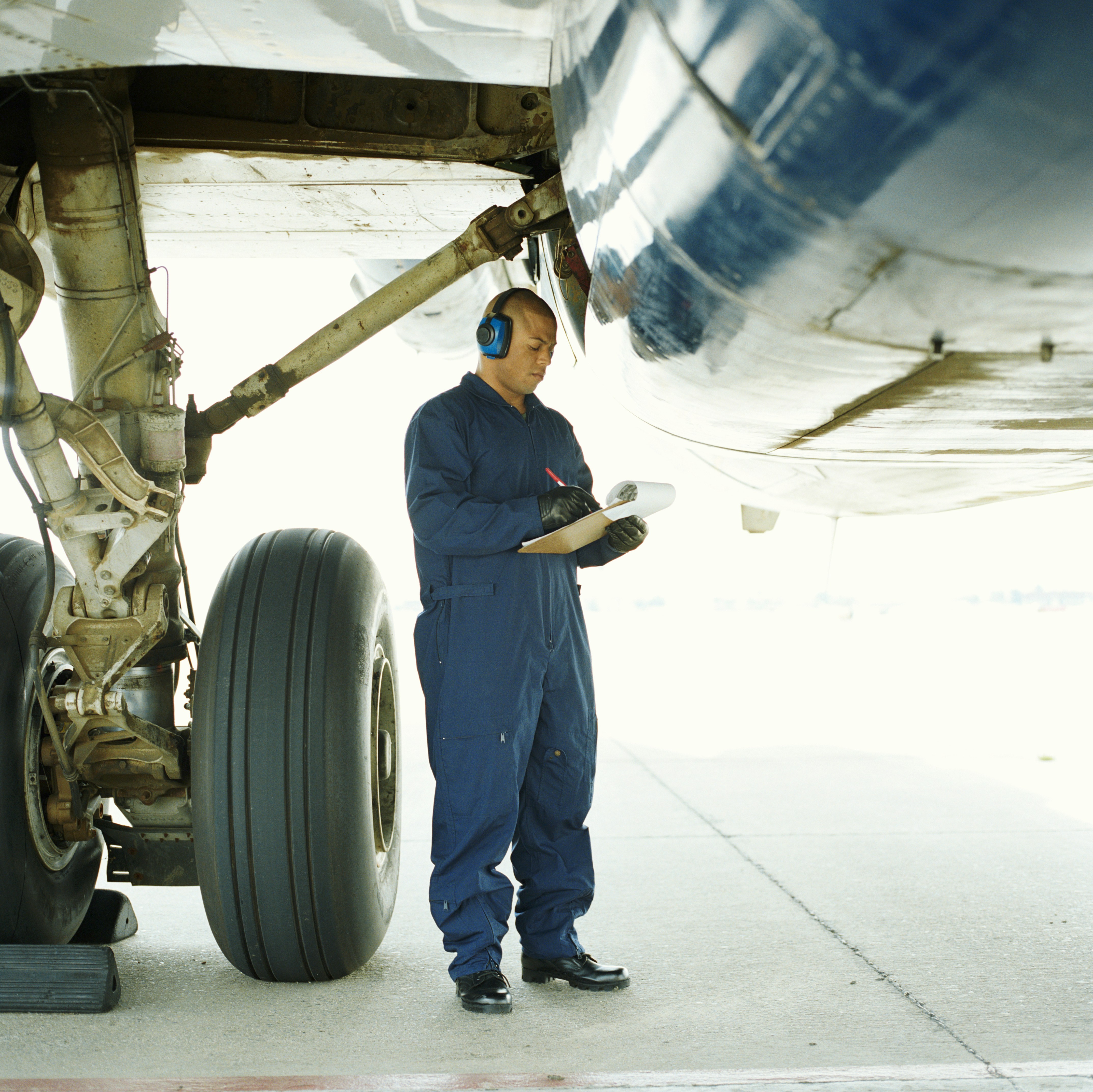 Aircraft mechanic inspecting landing gear